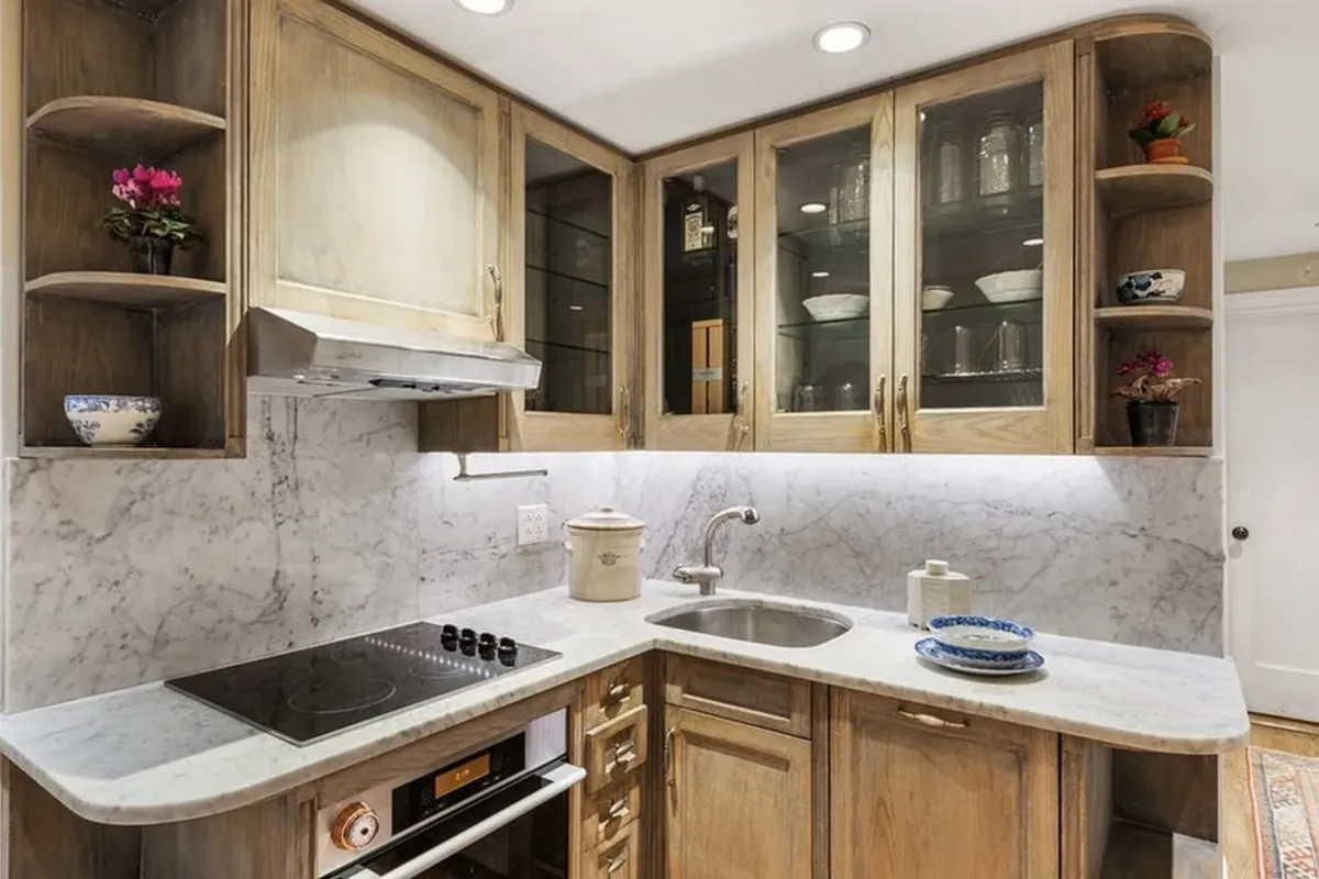 The renovated kitchen of Apartment 3F at 170 East 78th Street with marble counters and wood cabinetry