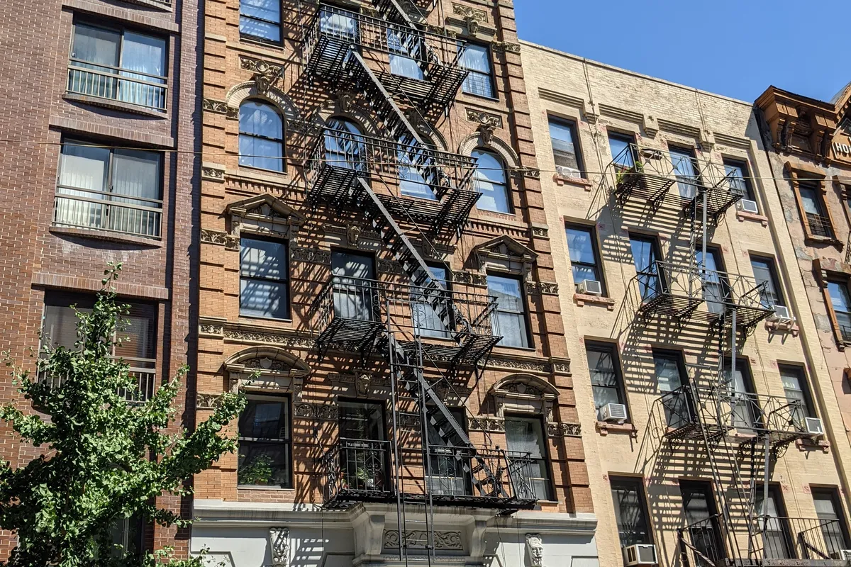 The five-story brick walk-up at 245 East 77th Street, a few doors west of the building site on the same block, photographed in 2021 (the street, not the building)