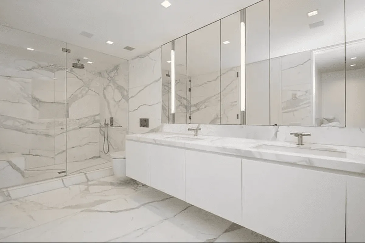 Marble primary bathroom with double vanity and glass shower at 40 East 61st Street, unit 6C