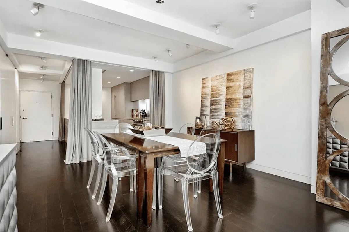 Dining area with wood table and clear acrylic chairs at 40 East 61st Street, unit 6C