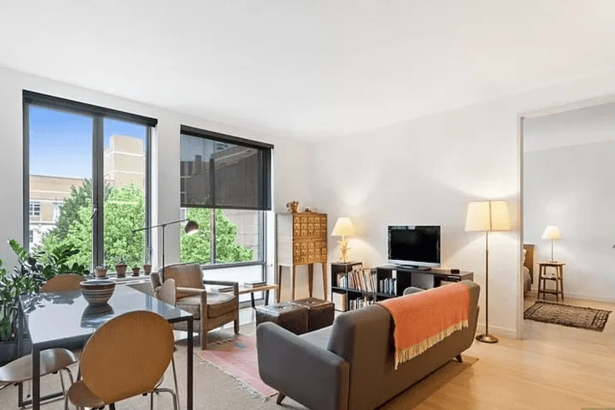 Sun-filled living and dining room with large windows, wood floors, and modern furniture at 49 North 8th Street