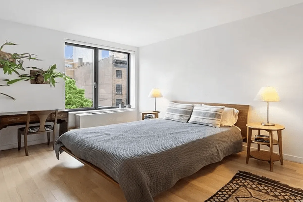 Primary bedroom with large window, wood-framed bed, and city views at 49 North 8th Street