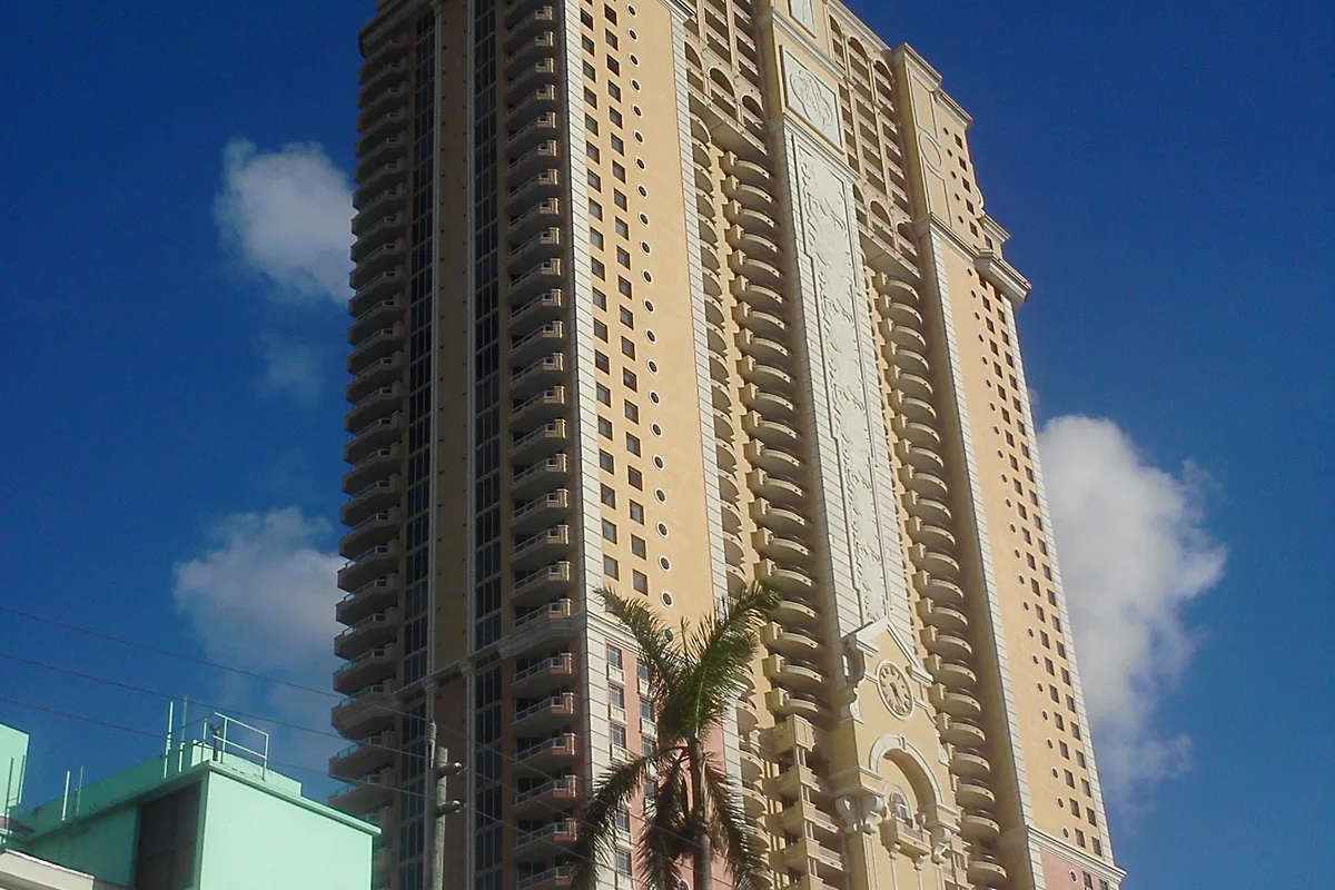 Acqualina tower in Sunny Isles Beach against a blue sky, seen from street level
