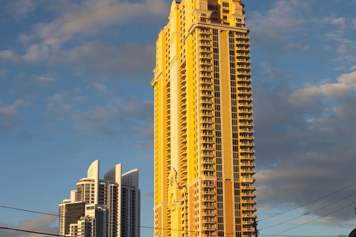 Acqualina Resort & Residences tower glowing gold at sunset over Collins Avenue, Sunny Isles Beach