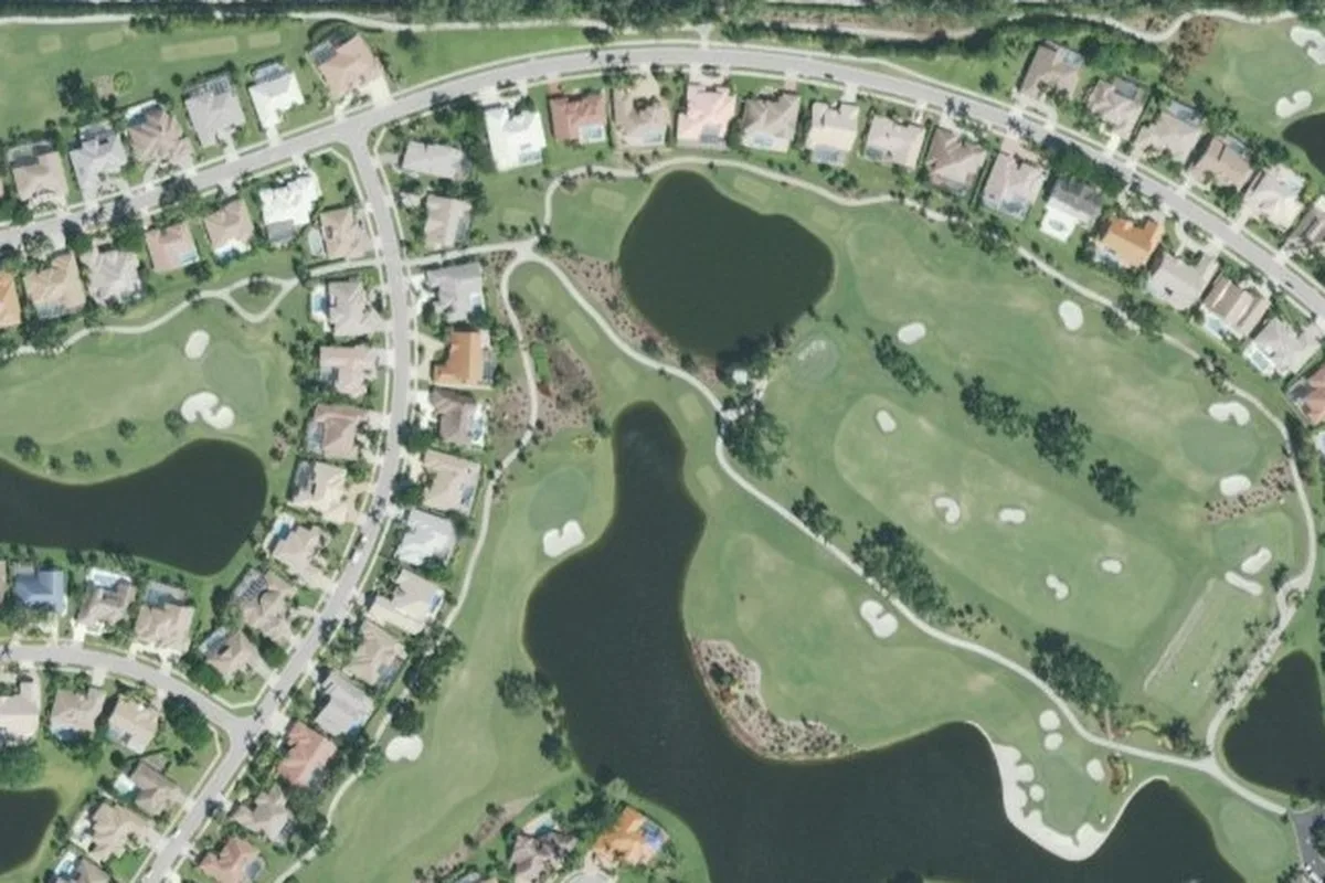 Aerial view of Stonebridge fairways, bunkers, and a lake ringed by single-family homes