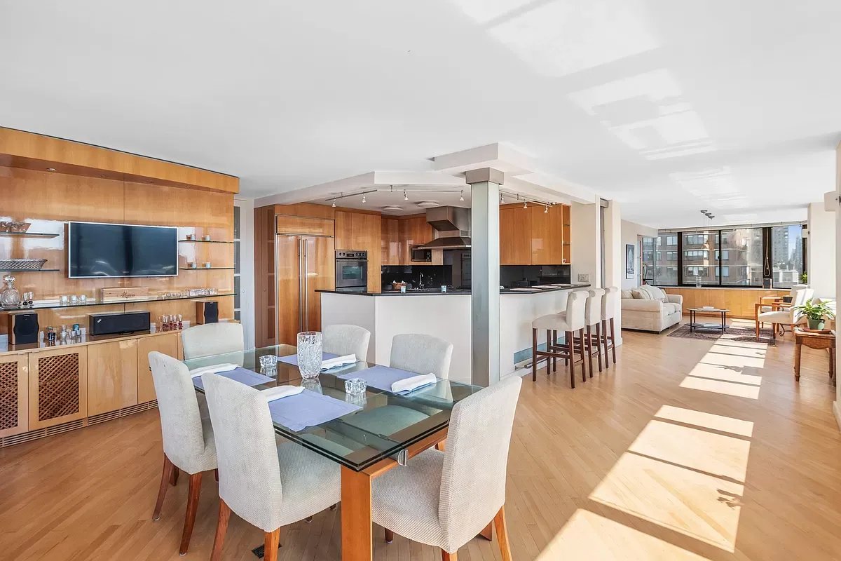 Open living and dining room with walnut millwork in a full-floor residence at The Bentley