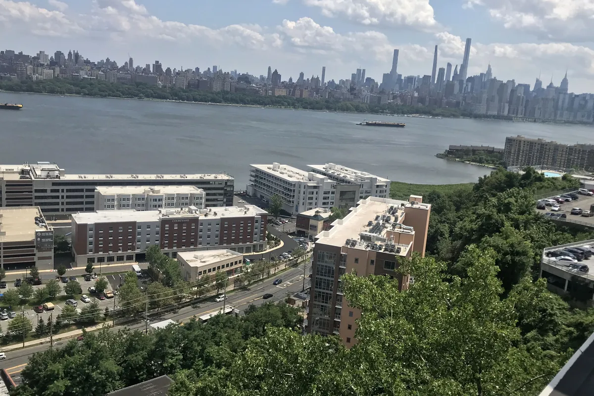 Edgewater Harbor from the Palisades, with The Glass House on the riverbank and the Manhattan skyline across the Hudson